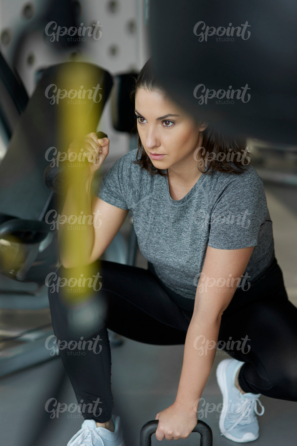 Female athlete with kettlebell exercising at gym