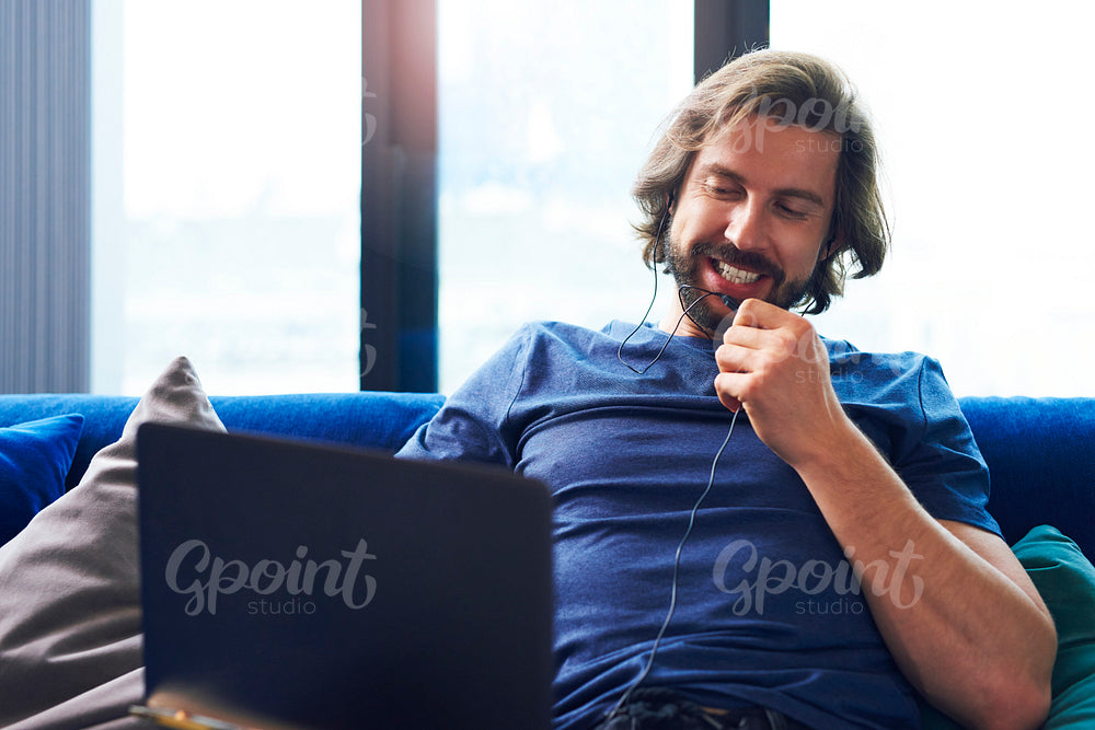 Young adult man using laptop in living room