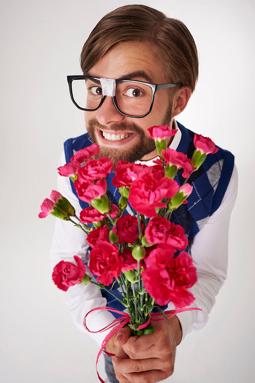 Portrait of geek holding flower bouquet