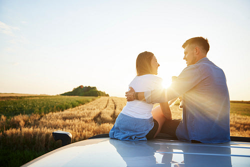 Rear view of loving couple catching a break during road trip