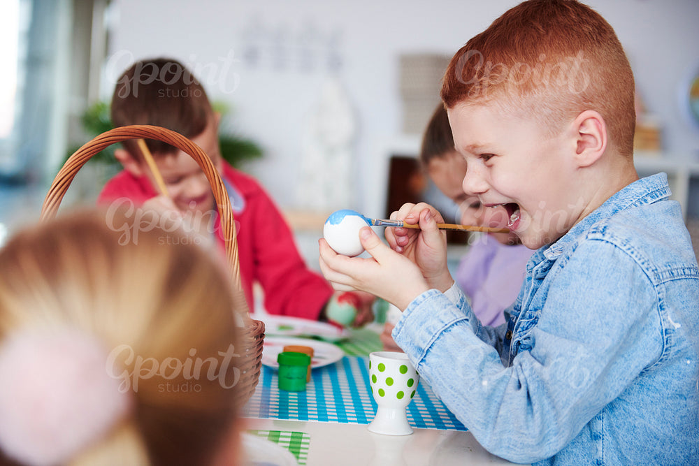 Screaming boy painting easter egg