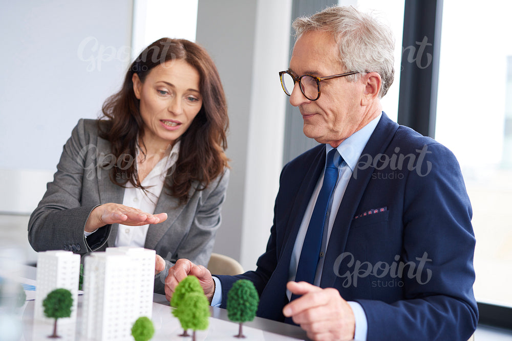 Business couple over architectural model