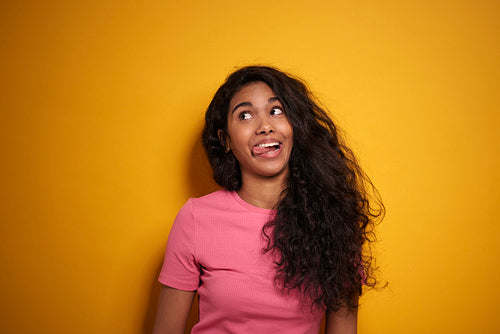 Funny dark skinned woman on yellow background