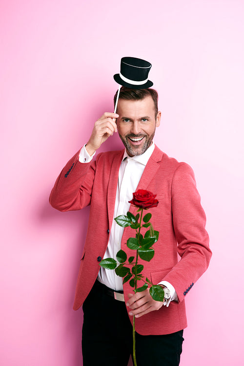 Man in red suit giving a rose