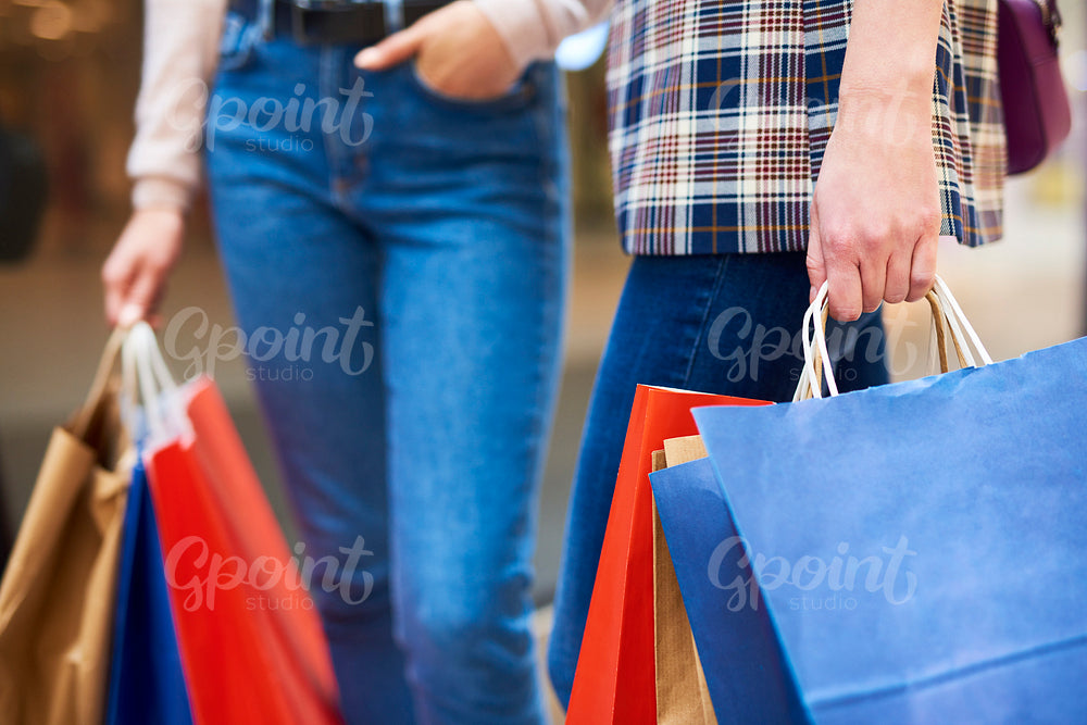 Low section of women carrying shopping bags
