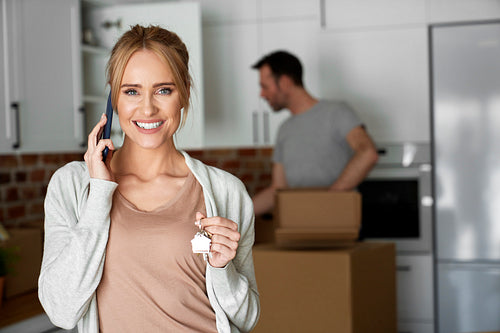Portrait of happy woman calling and holding house keys