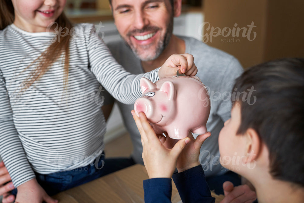Close up of happy father with children savings money