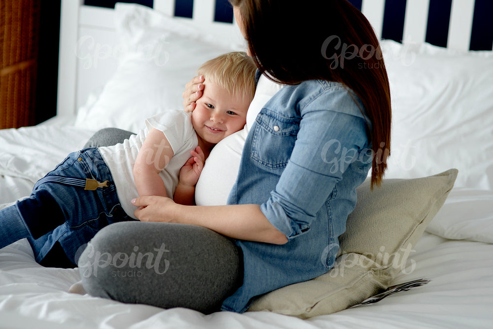 Pregnant woman embracing her little child
