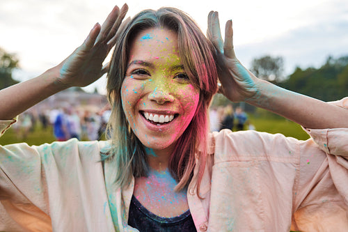 Face of smiling woman with coloured powder at Holi Festival