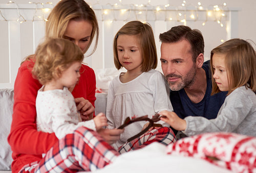 Parents and kids spending Christmas morning in bed