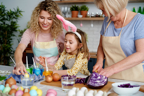 Three generations of women making Easter eggs