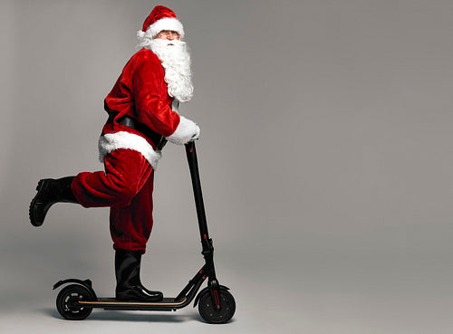Santa Claus riding an electric scooter