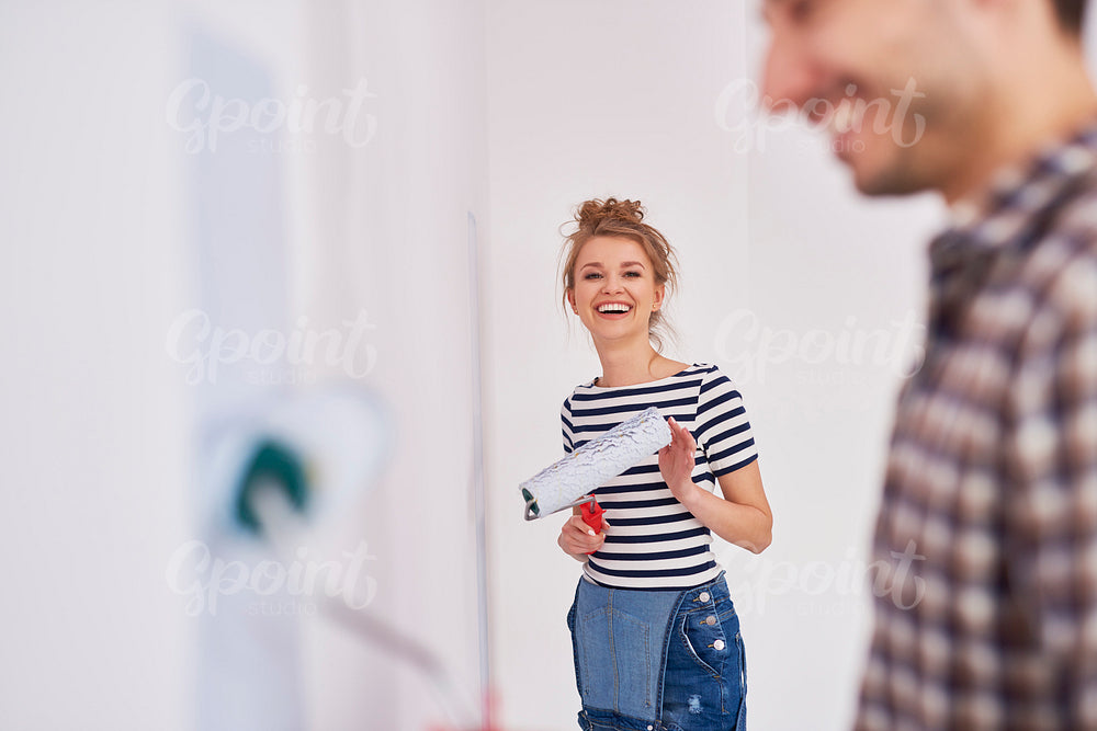 Portrait of smiling woman painting walls in her new flat