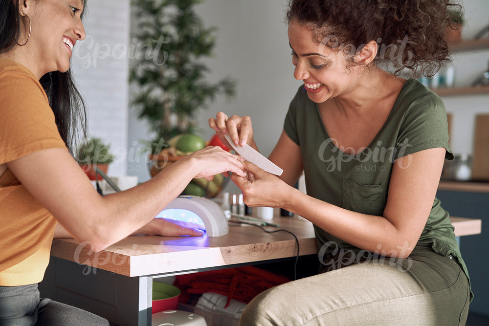 Happy women making nail beauty treatments at home