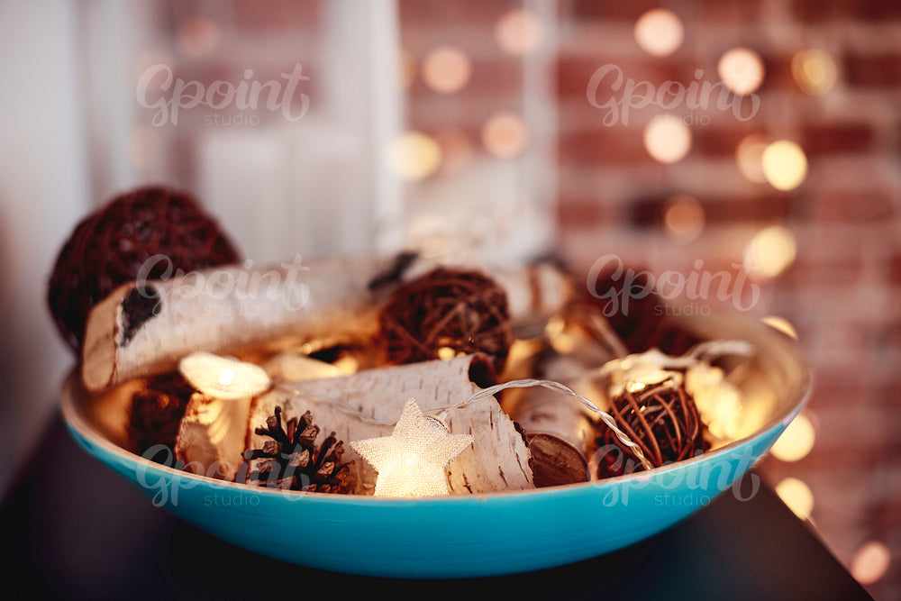 A bowl full of christmas wooden decorations
