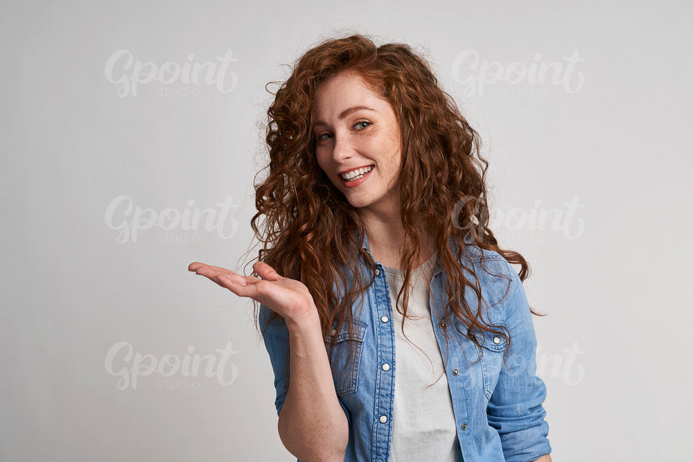 Smiling adult woman showing at empty copy space 