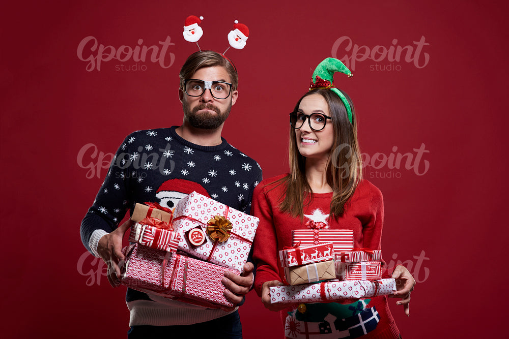 Happy couple with gifts on red background