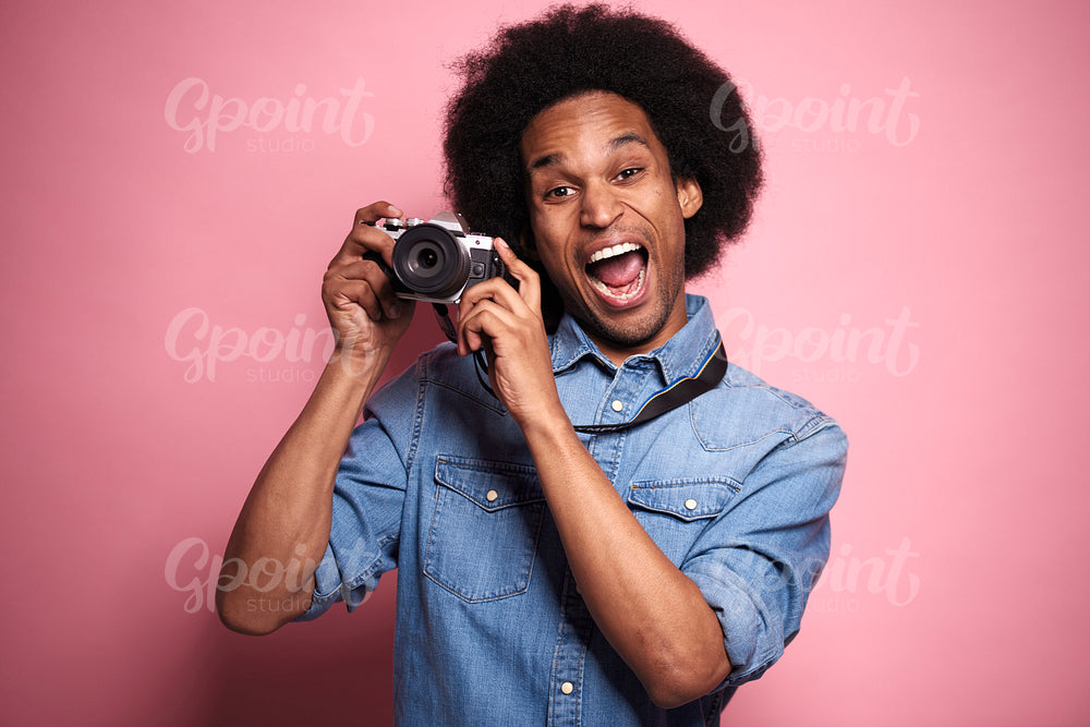 Happiness African man with digital camera in studio shot.