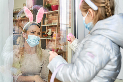 Girl showing her mother an Easter egg during quarantine