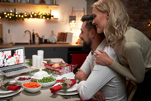 Loving couple during video conversation at the Christmas table