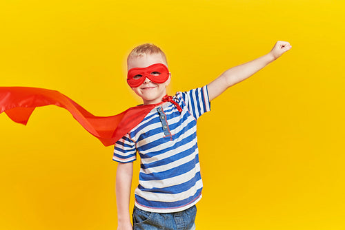 Portrait of playful boy in superhero costume