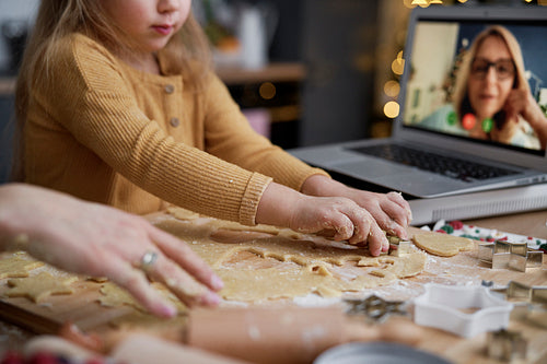 Close up of little girl cutting out cookies from the dough