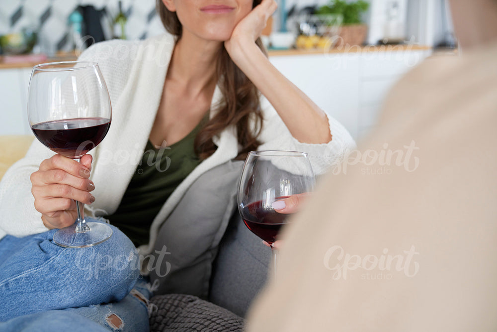 Two friends chatting and drinking wine
