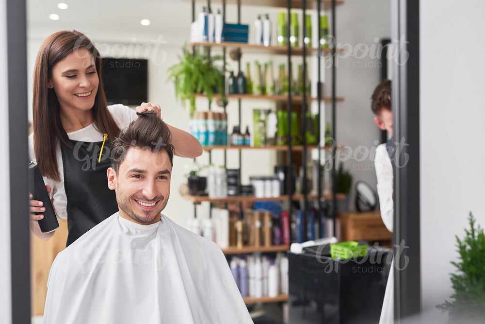 Smiling male customer sitting in hair salon