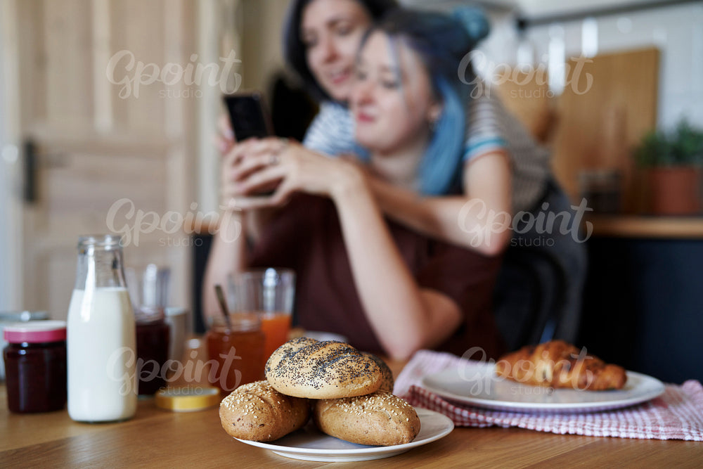 Breakfast on the table and lesbian couple in the background