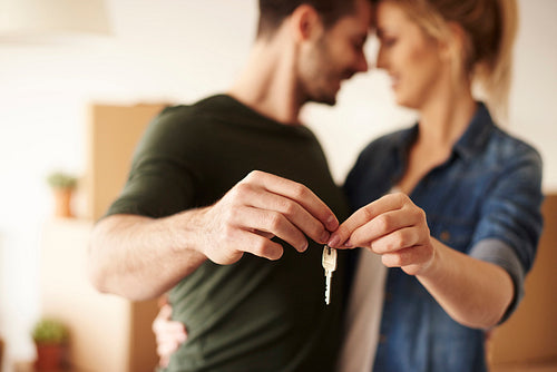Young couple holding up new house key