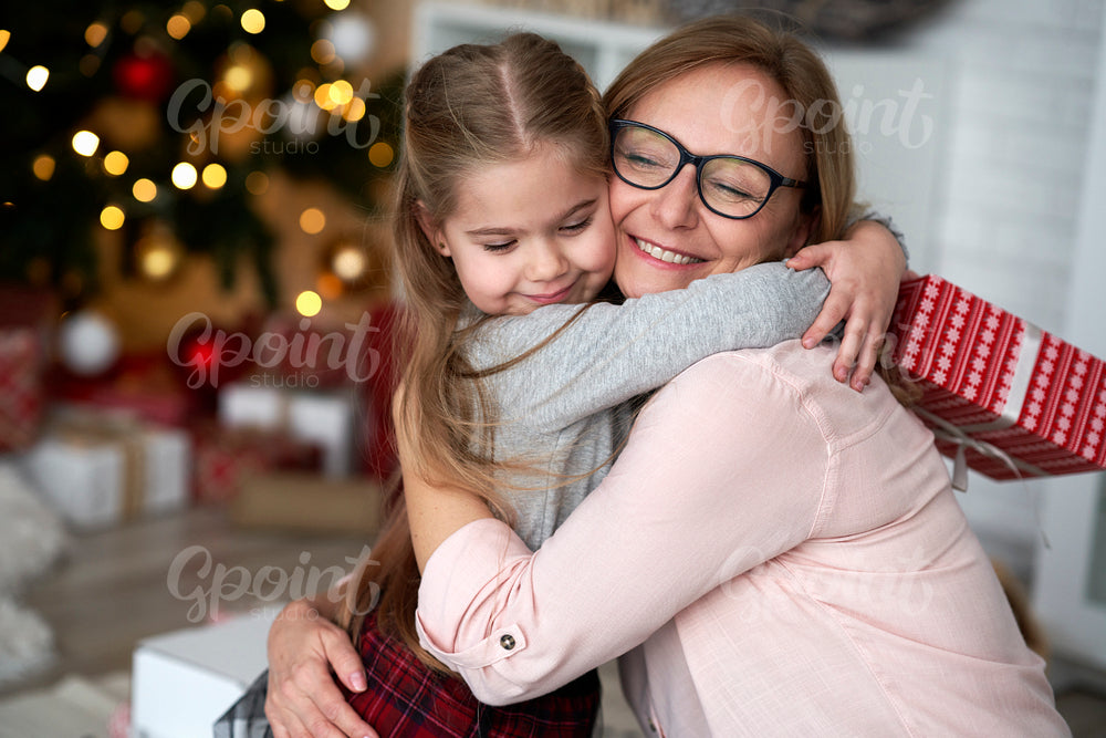 Granddaughter embracing her grandmother in Christmas time.