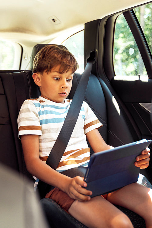 Boy looking at a tablet in the car