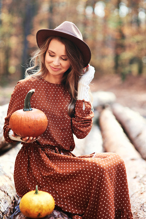 Woman sitting and holding some pumpkins