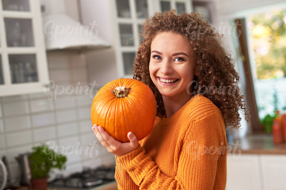 Portrait of beautiful woman holding a  pumpkin