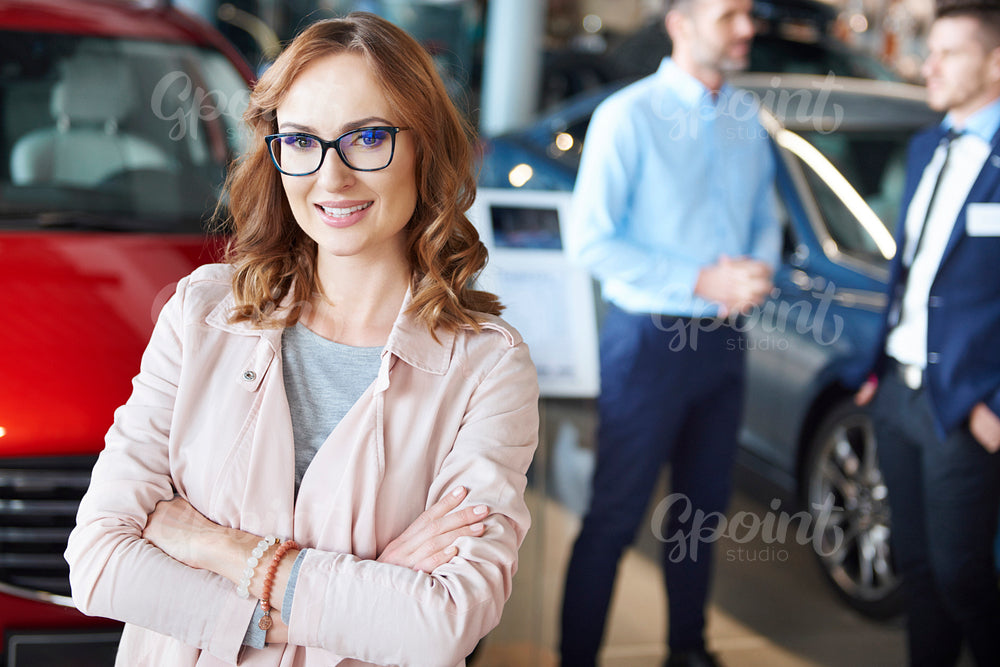 Portrait of confident woman in the car dealership