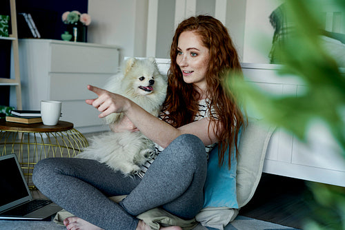 Redhead woman with a dog in the living room