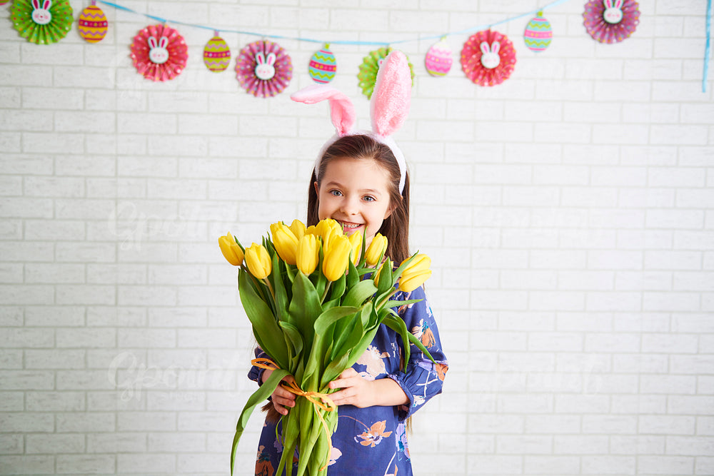 Happy girl holding bunch of yellow tulips