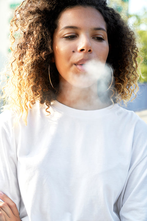 Young woman standing and smoking cigarette