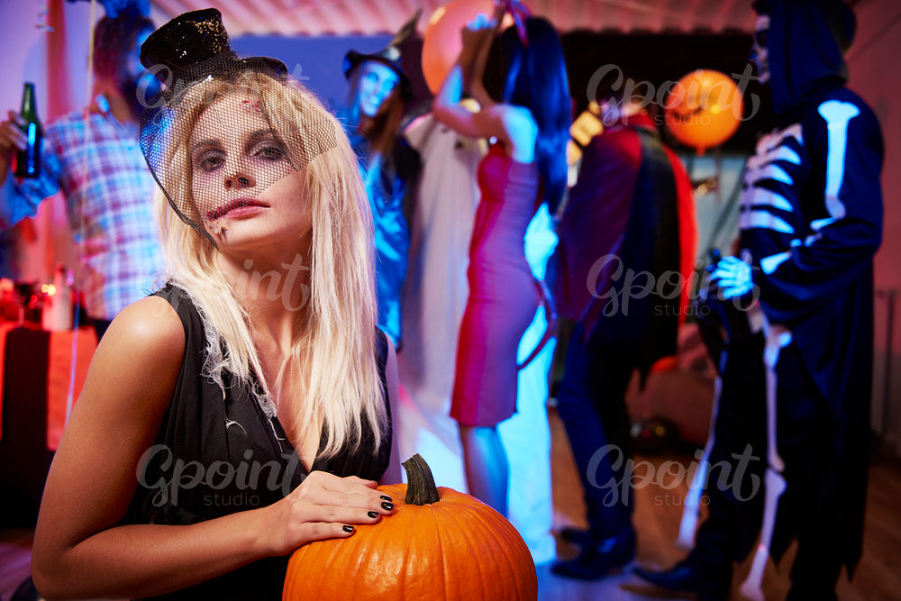 Spooky girl with orange pumpkin