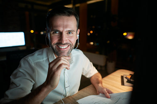 Portrait of smiling businessman working late in his office