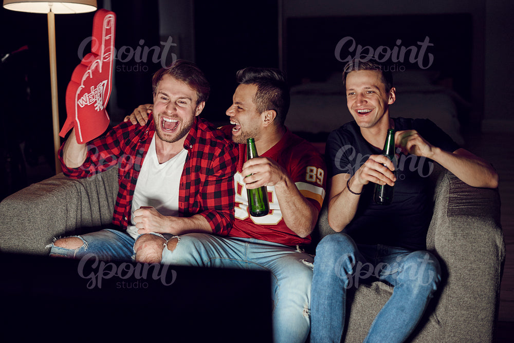 Men with foam hand and beer at football party
