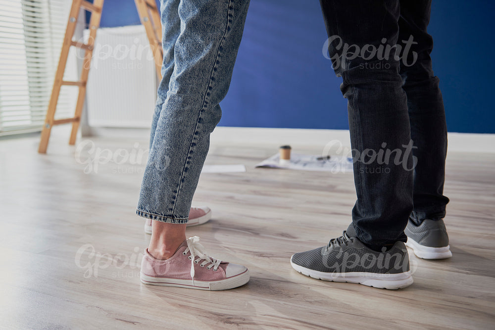 Legs of couple standing in new apartment