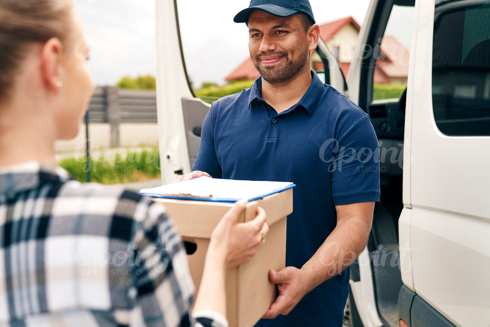 Smiling delivery person giving package to woman