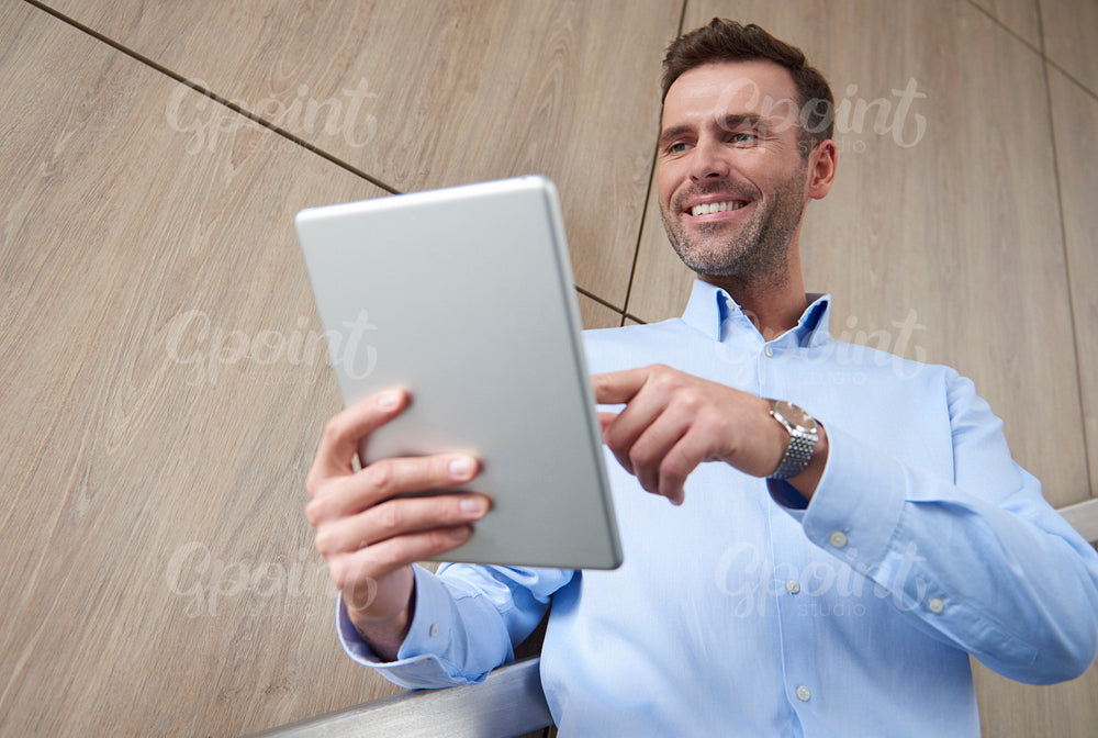 Low angle view of man with digital tablet