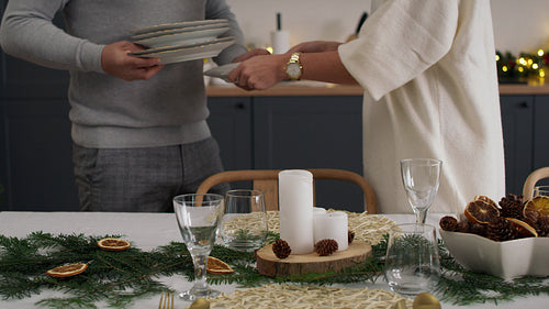 Couple preparing table for Christmas Eve