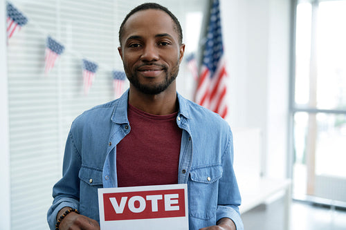 Black man with voting card