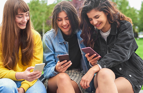 Three beautiful women looking at smart phones