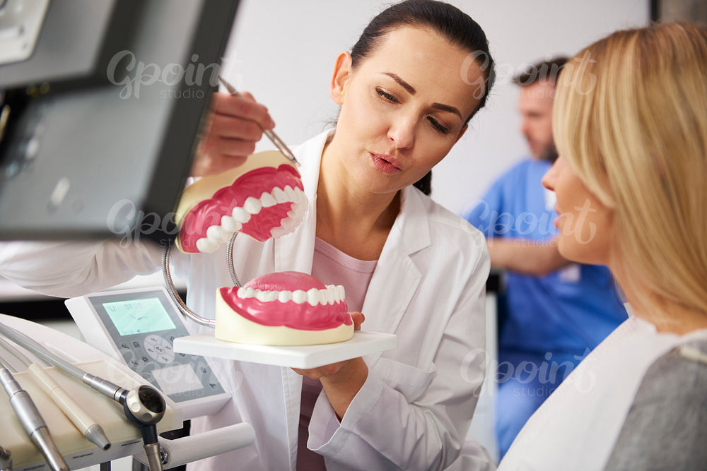 Dentist and young woman making a conversation in dentist's office