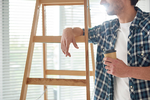 Man having coffee break while house renovation
