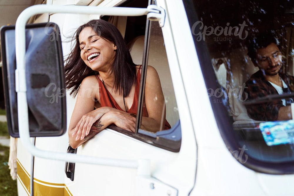 Cheerful mixed race woman  sticking out of camper's window